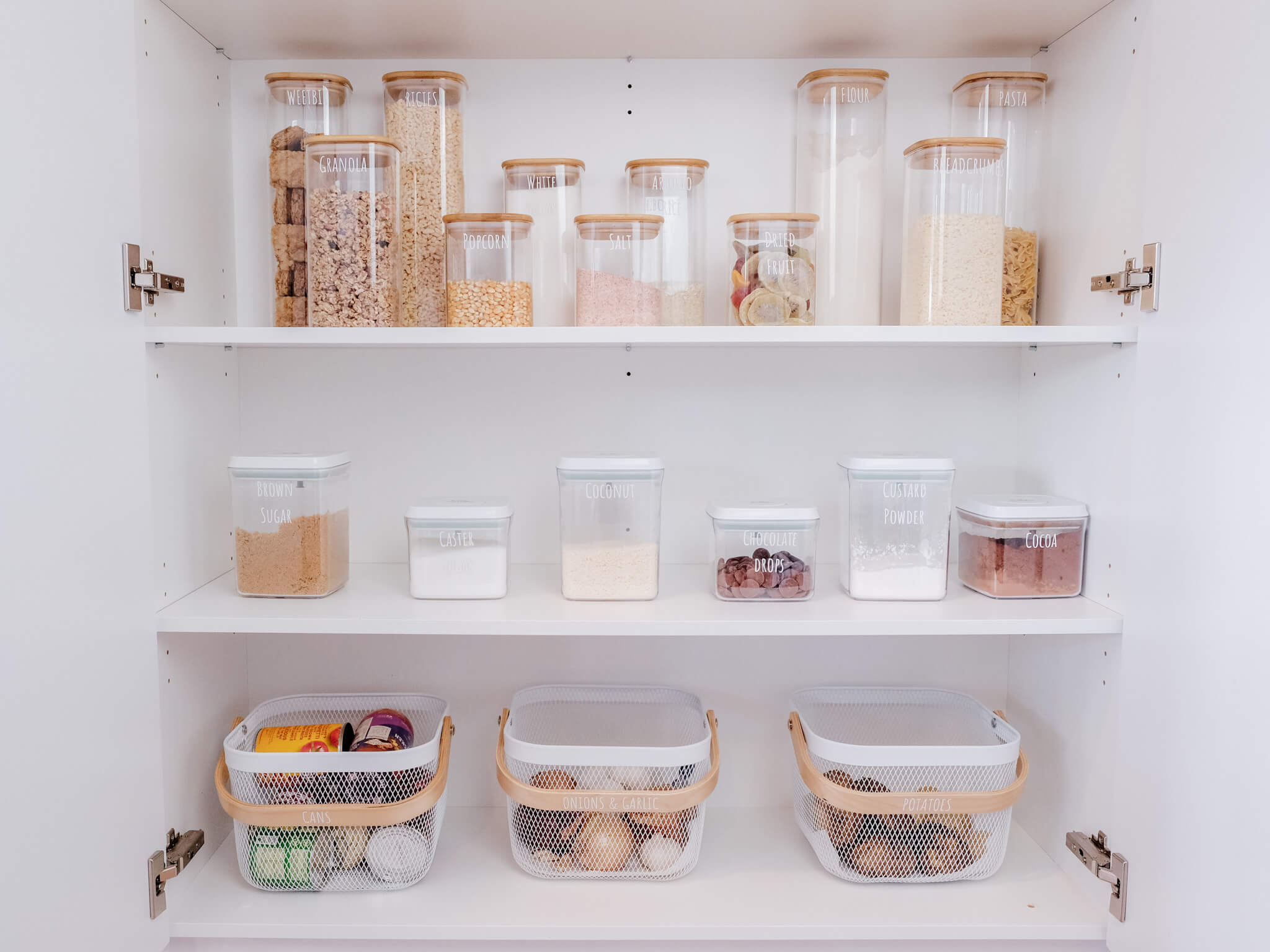 Organised pantry with clear airtight containers neatly storing dry goods, creating a clean, functional, and visually pleasing space.