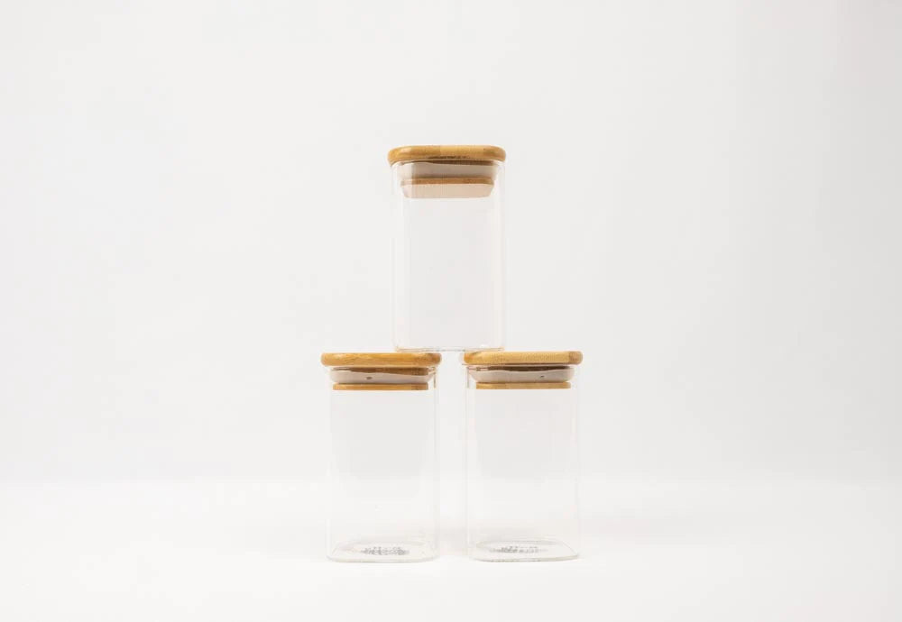 Square glass spice jars with bamboo lids, ideal for pantry organisation, kitchen storage, and decluttering services NZ.