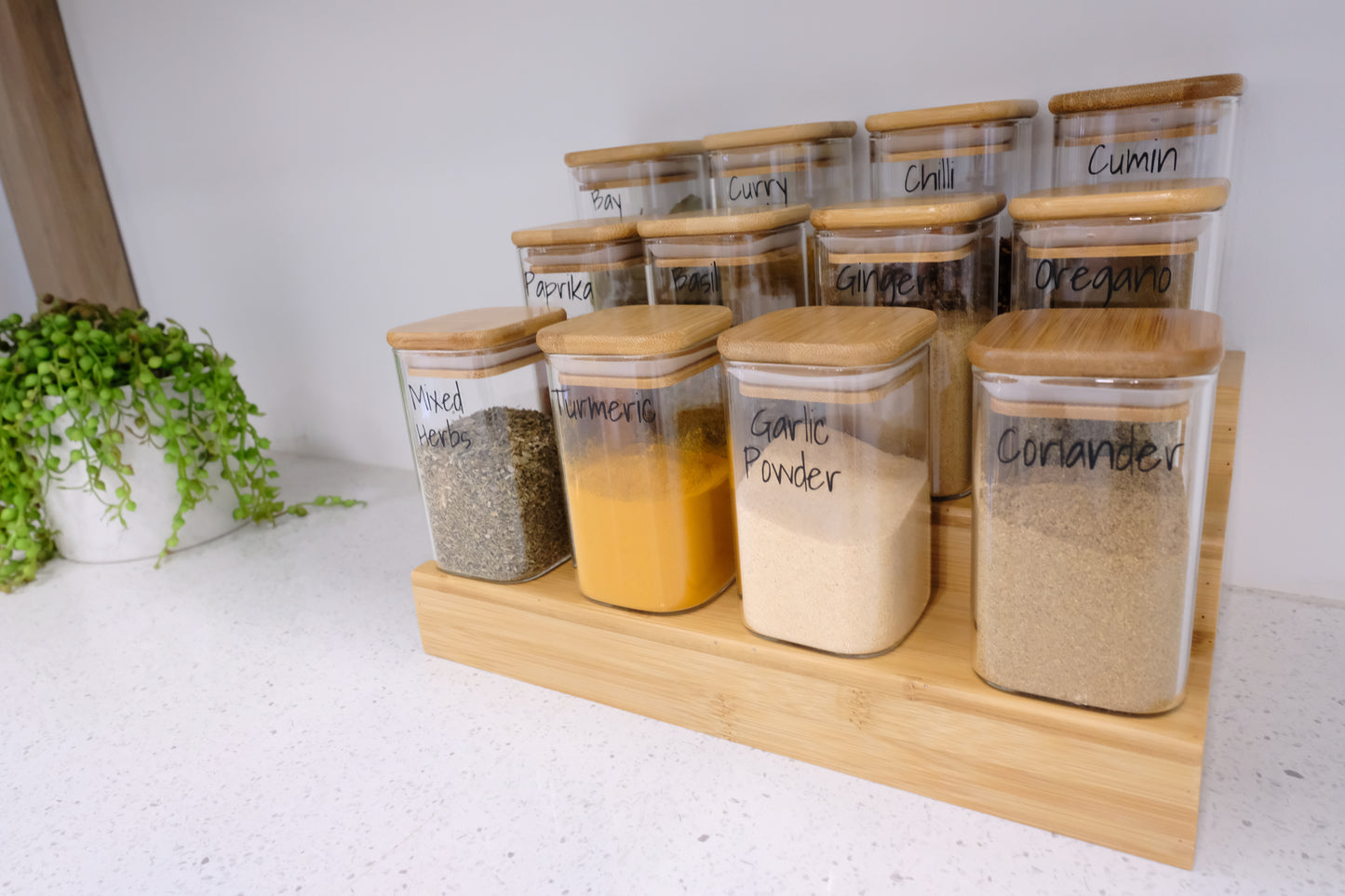 Glass square spice jars on bamboo rack, perfect for pantry organisation and kitchen storage in NZ homes.