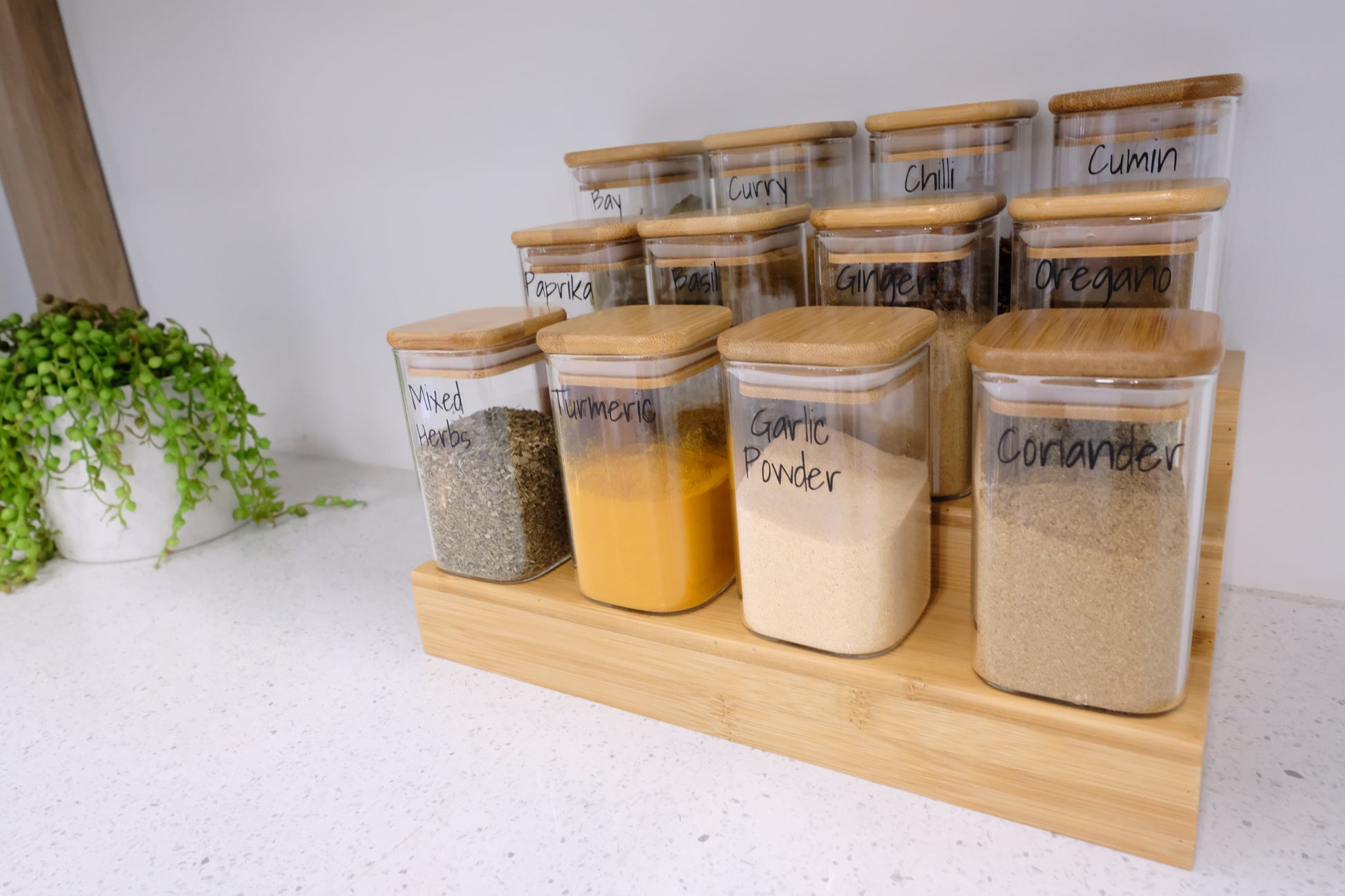 Organised glass spice jars on a bamboo spice rack, perfect for pantry organisation and kitchen storage in NZ homes.
