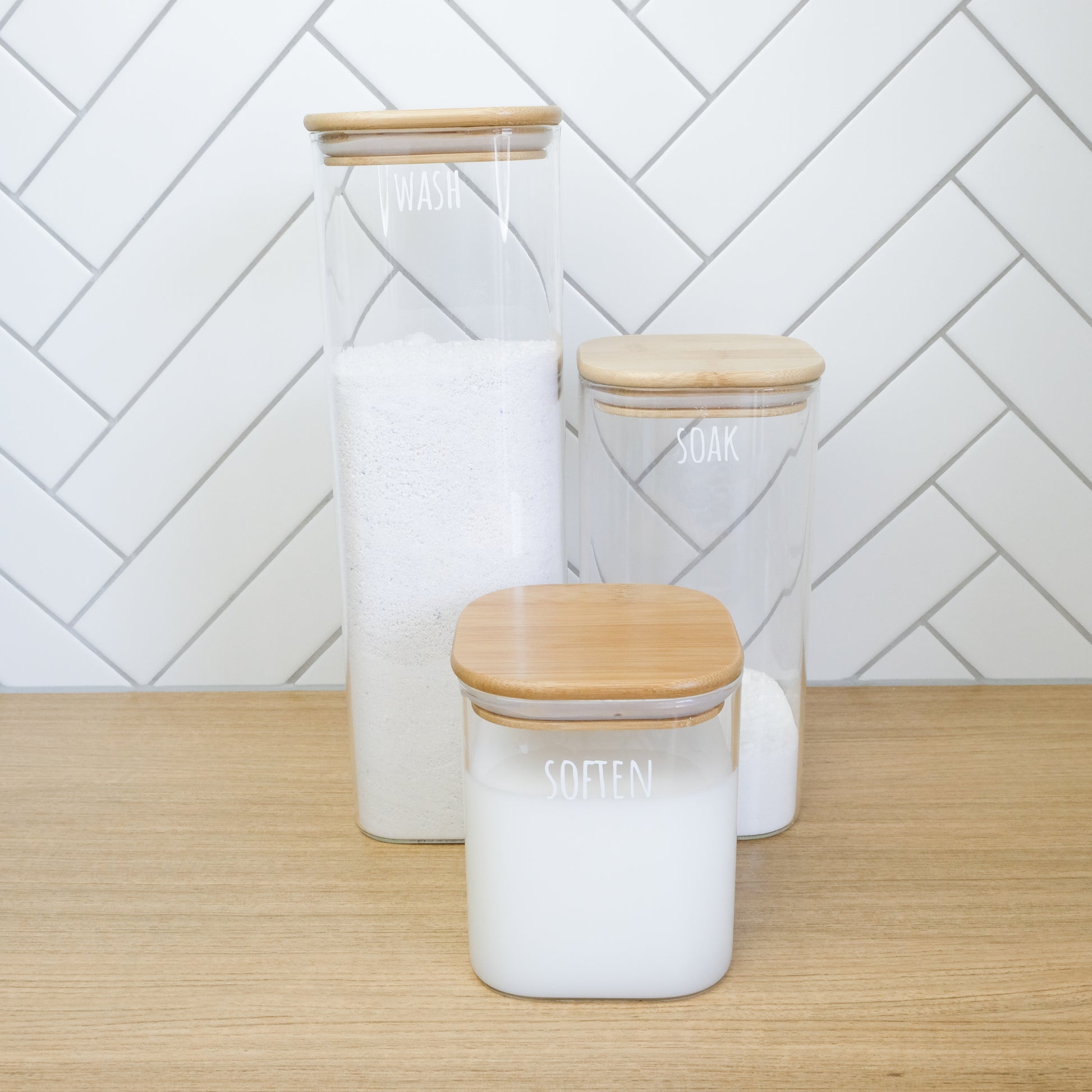 Square glass containers with bamboo lids, perfect for laundry organisation and home organisation services NZ.
