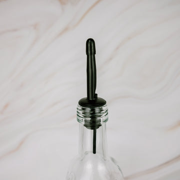 Black plastic pourer on glass oil bottle, ideal for kitchen storage and pantry organisation in NZ homes.
